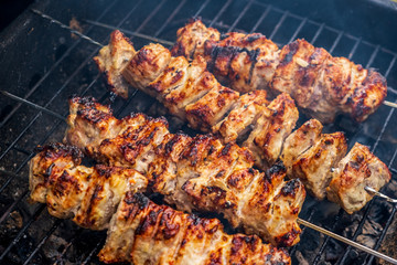 Traditional shashlik cooking on a grill isolated