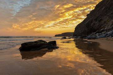Fototapeta na wymiar Feuriger Morgenhimmel am Strand von Watergate Beach, einem Surfer Hot Spot in Cornwall