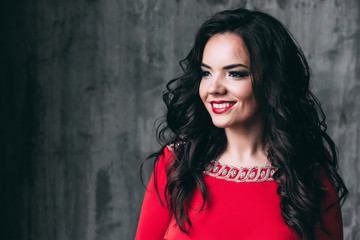 Portrait of a glamorous brunette in a red dress.