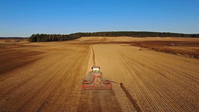4K. Aerial view of agriculture process: tractors are plows and makes seeding, sowing agricultural crops at field.