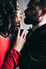 Portrait of the bride and groom. Red dress and black suit.