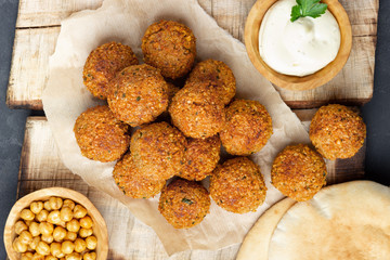 Vegetarian chickpeas falafel balls on wooden rustic board. Traditional arabian food. Dark...