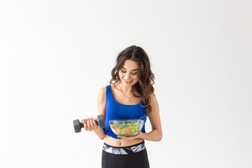 Healthy lifestyle, people and sport concept - Portrait of a healthy woman with vegetables and dumbbells