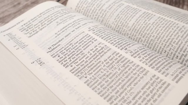 Camera turning around the holly bible being open on a table