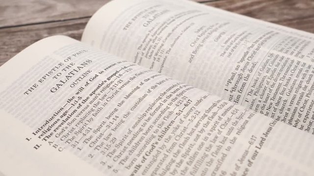 Camera turning around the holly bible being open on a table
