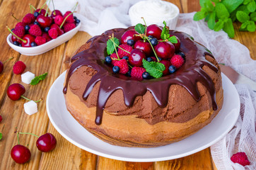 Marble cream cake with chocolate glaze, fresh berries, whipped cream and mint.