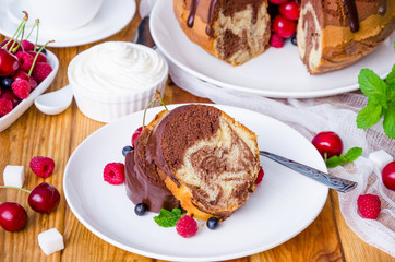 Marble cream cake with chocolate glaze, fresh berries, whipped cream and mint.