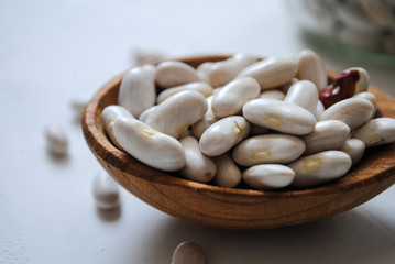 White beans in a wooden spoon
