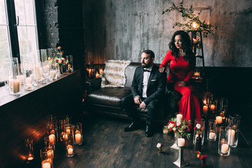 Photo session of the newlyweds in the studio. Red dress and black suit.