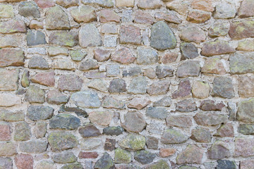 Old stone wall with rocks of different colors