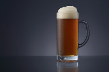 Frosty mug of beer on gradient gray