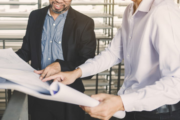 Consultant engineer discussing construction project in blueprint; Consulting concept in...