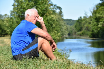 Athletic Grandfather Thinking Sitting By River