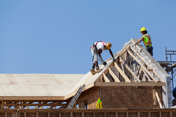 Carpenters are working on the house roof at construction