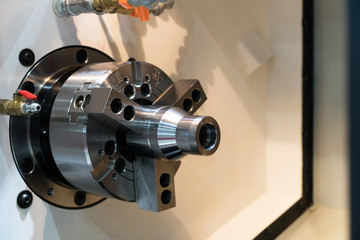Close up spindle chuck and product part set on high precision Cnc industrial lathe turning machine