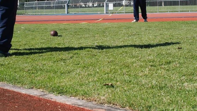 The referee measure the distance of shot put ball was thrown on the field by a athlete in the sport stadium.