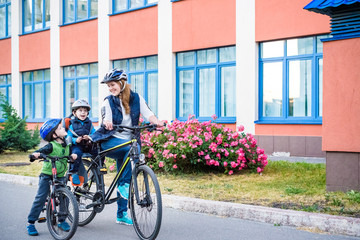 Fototapeta premium Family cycling, mother with happy kid riding bike outdoors