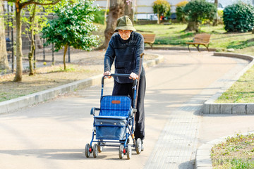 シルバーカーを押して散歩をする高齢者の女性