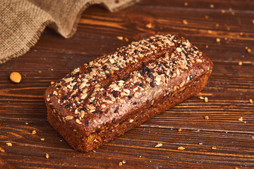 Whole wheat craft bread on wooden background. The concept of healthy food and traditional bakery. Rustic