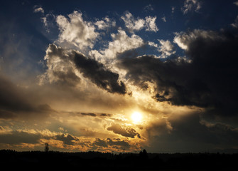 colorful golden sunset with blue sky and mighty clouds