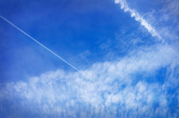 contrails and clouds at beautiful blue sky