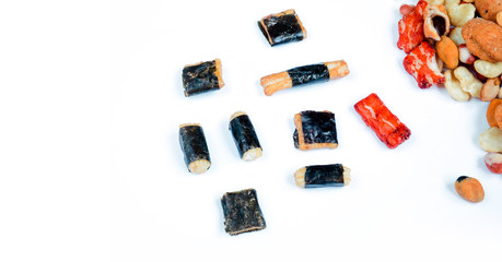 Mix of Asian snack on white background. Japanese nori maki arare rice crackers in seaweed, glaze peanuts. Close up with Space for text.