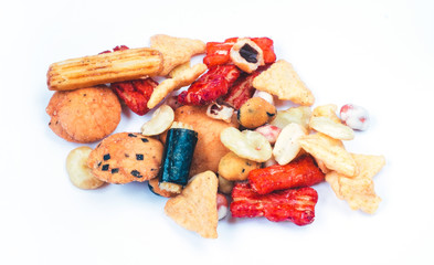 Mix of Asian snack on white background. Including Nori Maki Arare rice crackers in seaweed, glaze peanuts and fried crackers. Close up.