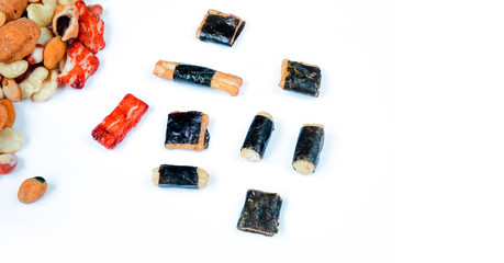 Mix of Asian snack on white background. Japanese nori maki arare rice crackers in seaweed, glaze peanuts. Close up with Space for text.