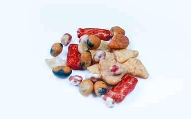 Mix of Asian snack on white background. Including Nori Maki Arare rice crackers in seaweed, glaze peanuts and fried crackers. Close up.