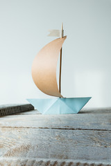 Segelboot aus Papier auf Holz