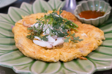 Omelette with crab meat on a green plate