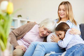 Obraz premium Portrait of grandmother and little girl listening to pregnant belly of smiling young woman, copy space