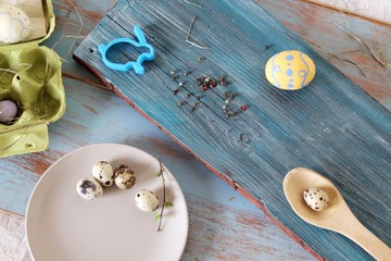 Eggs, quail, easter decor on a blue wooden table, top view