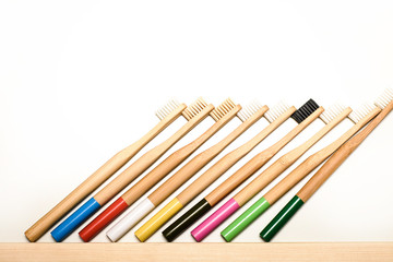 Fototapeta premium full colours bamboo toothbrushes on white background. Place for text. Ecoproduct. eco-friendly.