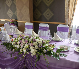 Wedding floral table decoration with candles in transparent vases
