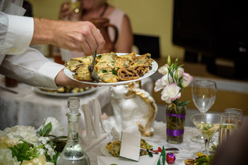 Waiter carrying plates with meat dish on some festive event, party or wedding reception