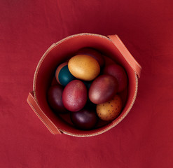 Painted colorful eggs on a red background in the Easter holiday. Place for text.