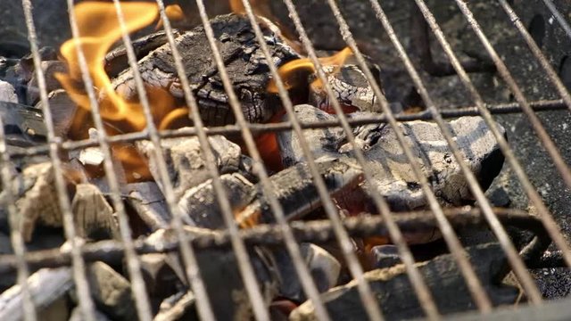 BBQ grill charcoal burning with an open flame in slow motion isolated