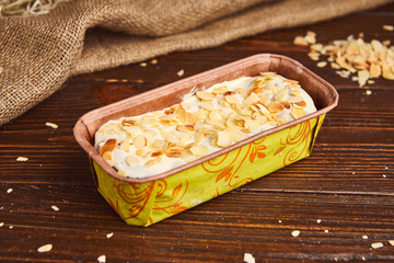 fresh classic vanilla cheesecake decorated by almond flake on wooden background