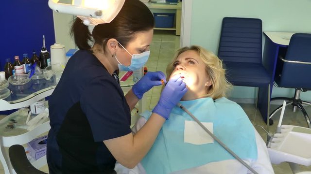 Kiev, Ukraine - April 2019: Girl at the reception at the dentist. Dentist treats teeth to the patient in the dental office. The dentist treats the patient in the clinic.