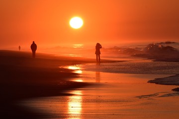 Fototapeta premium silhouette of people on the beach at sunset