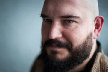Portrait of a bald man in a shirt with a beard