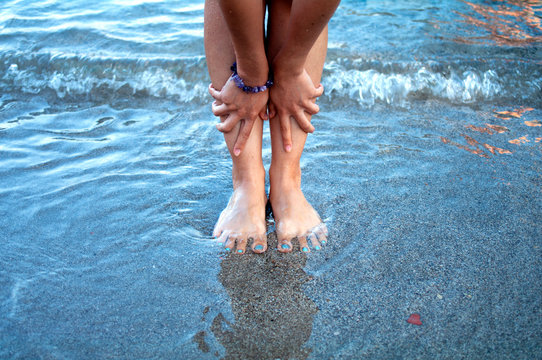 Beautiful woman hands and feet on beach