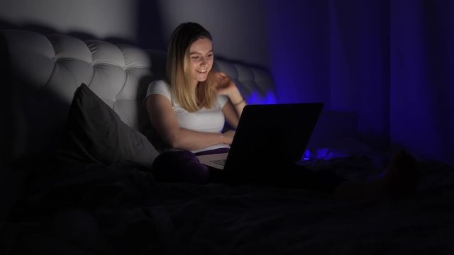 girl laughs in front of a laptop
