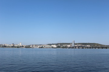 Fototapeta na wymiar City panorama. Bridge over river at summer day