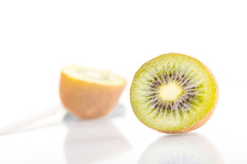 Green fresh kiwi fruit cut into half on a white background