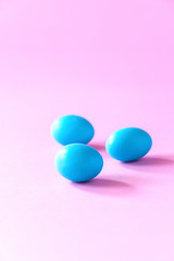 Three small blue eggs on pink background. Easter celebrate concept. Copy space.
