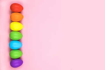 Obraz premium Colored Easter eggs on pink background. Flatlay.
