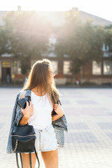 Pretty smiling brunette girl walking on the street.