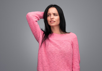 Fototapeta premium Thoughtful female looking away and scratching head